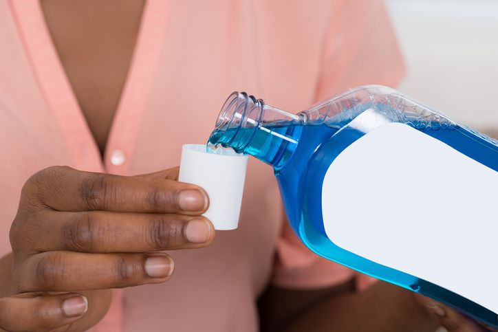 Person-Pouring-Mouthwash-Into-Bottle-Cap-622201158_727x485